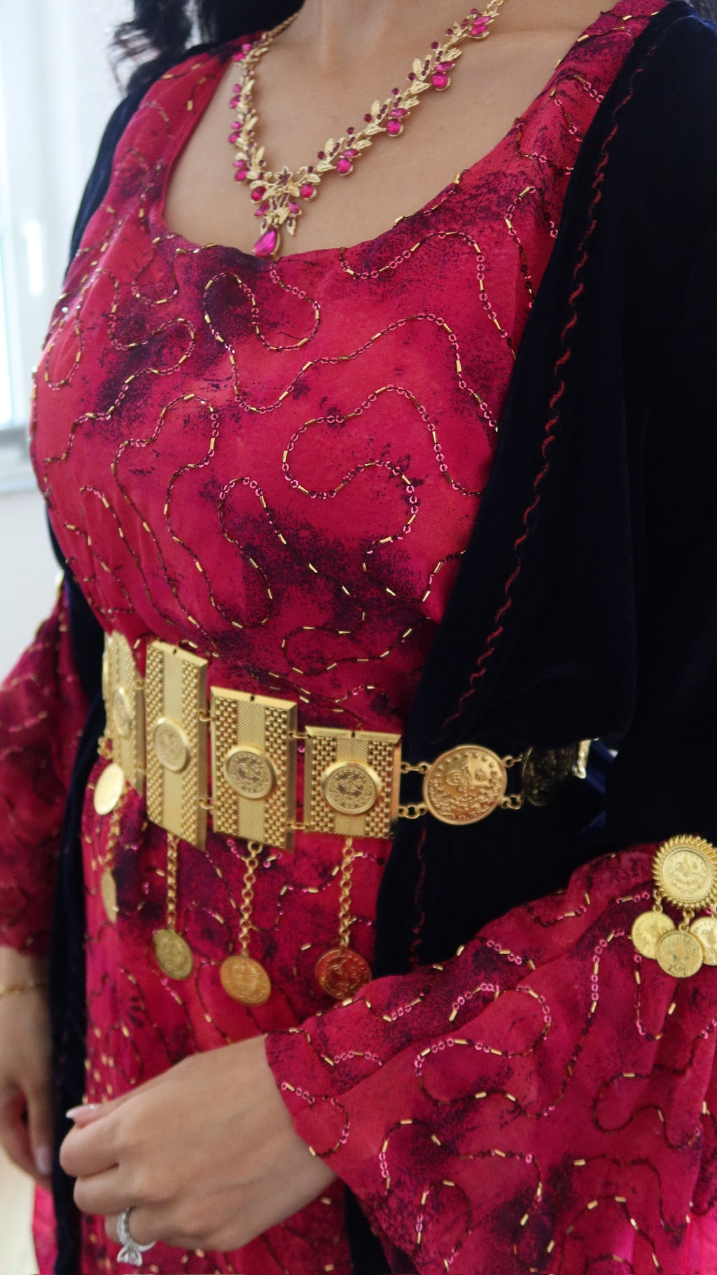 Red traditional outfit with gold jewelry and belt
